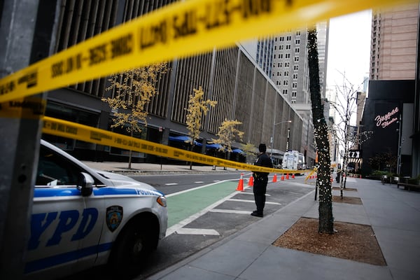 A New York police officer stands on 54th Street outside the Hilton Hotel in midtown Manhattan where Brian Thompson, the CEO of UnitedHealthcare, was fatally shot Wednesday, Wednesday, Dec. 4, 2024, in New York. (AP Photo/Stefan Jeremiah)