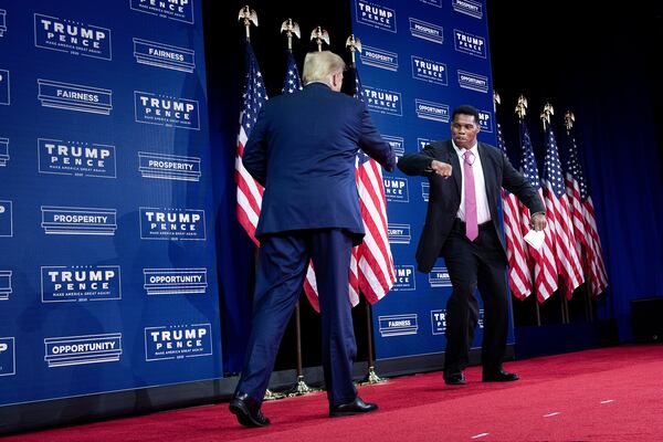 Former President Donald Trump, left, has called on University of Georgia football legend Herschel Walker to run next year in the state's U.S. Senate race. Walker has been noncommittal, so far. (Brendan Smialowski/AFP via Getty Images/TNS)