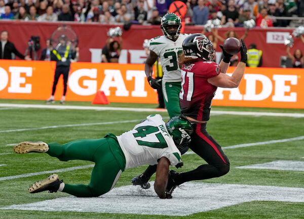 Falcons tight end Hayden Hurst (81) gets into the end zone to score a touchdown despite the challenge of New York Jets defensive end Bryce Huff (47) during the first half Sunday, Oct. 10, 2021, at the Tottenham Hotspur stadium in London, England. (Alastair Grant/AP)