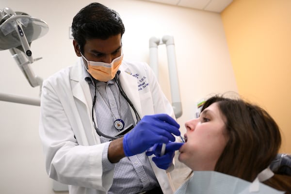 Alexander Daniel, DDS, left, demonstrates fluoride treatment on resident Cameron Onken, right, at the Johns Hopkins Outpatient Center, Friday, Feb. 28, 2025, in Baltimore. (AP Photo/Nick Wass)