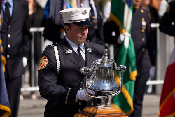 A member of the honor guard rings a bell for a moment of silence during a ceremony marking the anniversary of the 1993 World Trade Center bombing at the 9/11 Memorial, Wednesday, Feb. 26, 2025, in New York. (AP Photo/John Minchillo)