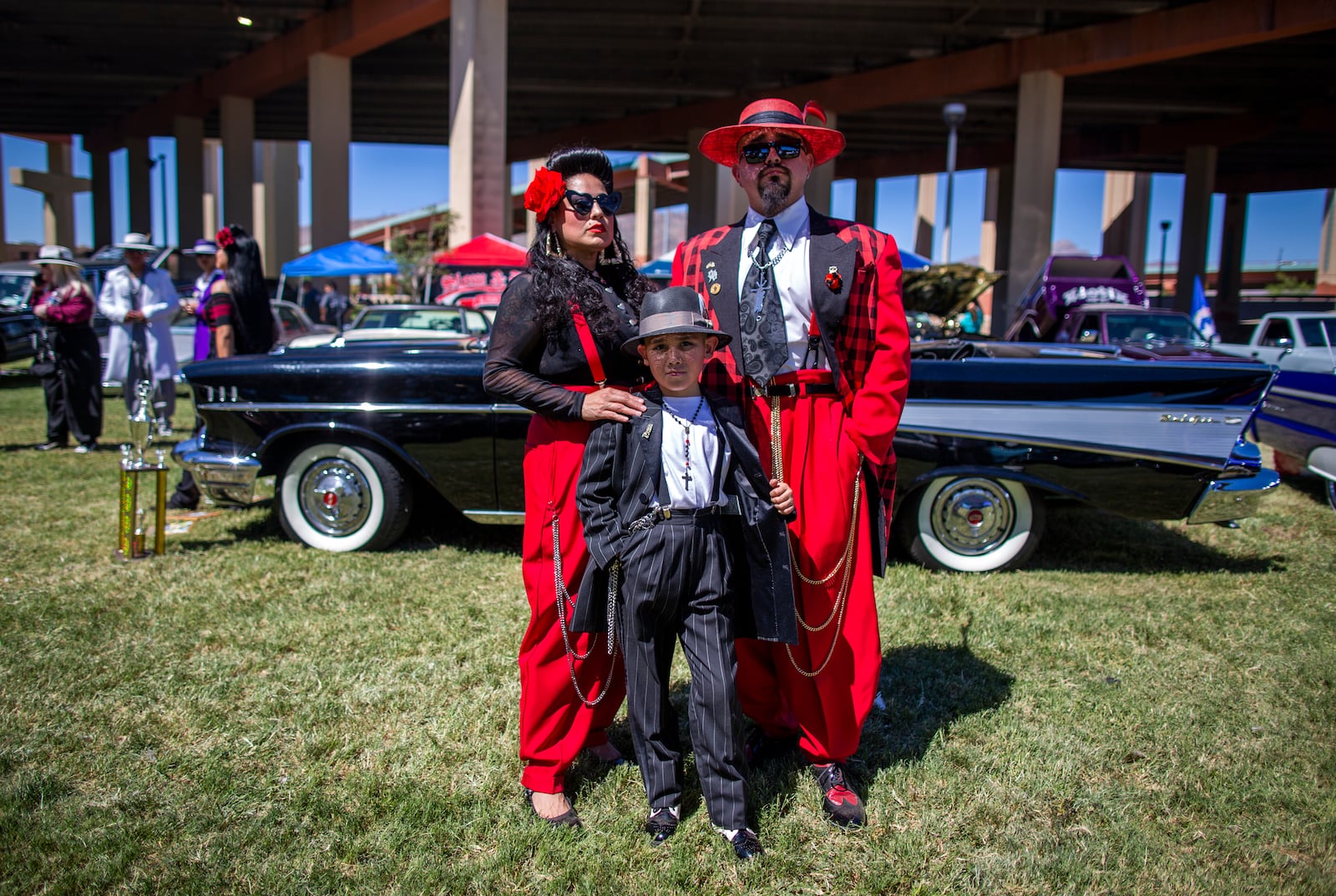 Wearing Zoot suits of the Mexican American subculture known as Pachucos, Paula, Jacob, center, and Junior Hernandez pose for a photo while attending a lowrider exhibition during the 20th anniversary of Lincoln Park in El Paso, Texas, Sunday, Sept. 22, 2024. (AP Photo/Andrés Leighton)