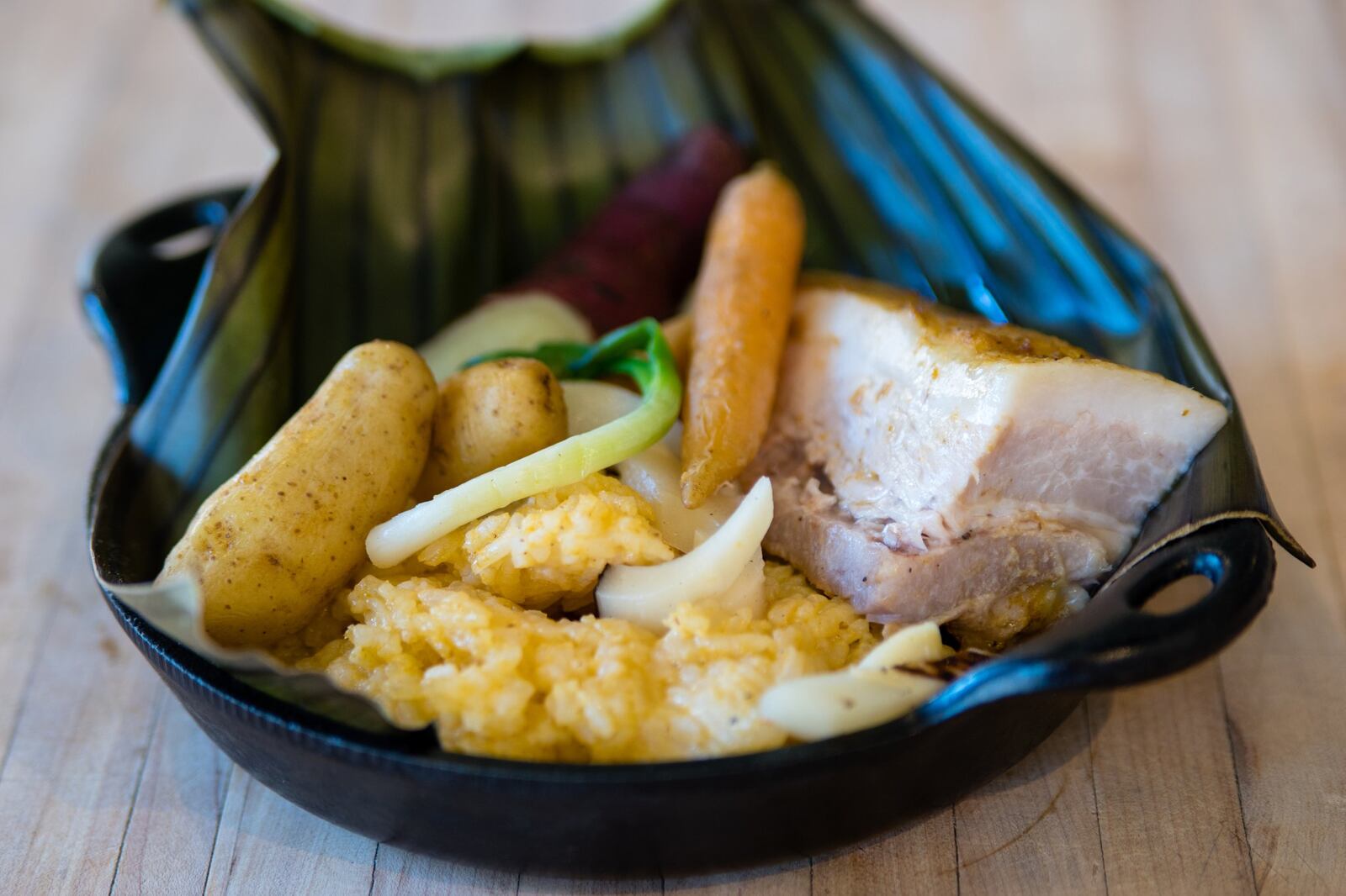 The tamal costeño, Colombian braised pork belly in a banana leaf, at Gunshow. CONTRIBUTED BY HENRI HOLLIS