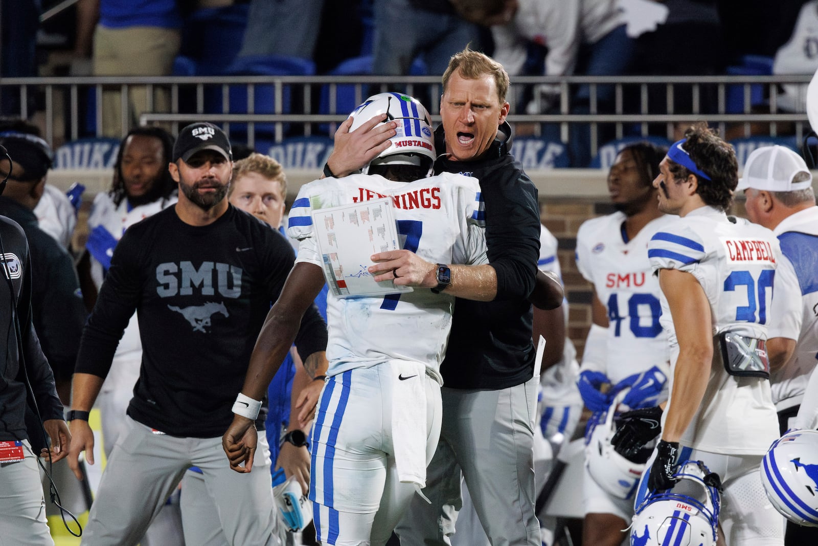 SMU head coach Rhett Lashlee, right, celebrates with quarterback Kevin Jennings (7) after scoring a touchdown during the second half of an NCAA college football game against Duke in Durham, N.C., Saturday, Oct. 26, 2024. (AP Photo/Ben McKeown)