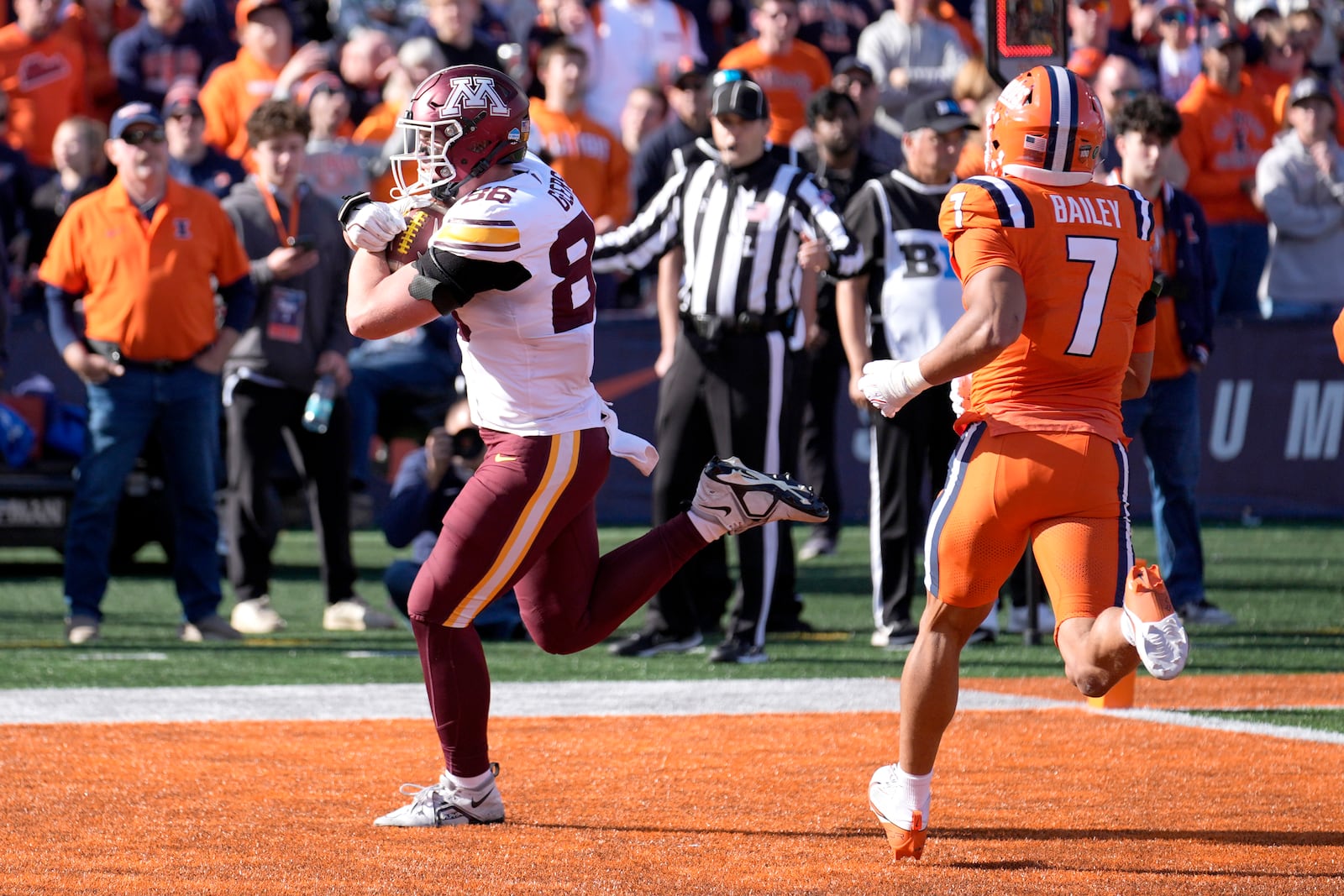 Minnesota tight end Jameson Geers catches a touchdown pass past Illinois defensive back Matthew Bailey, from quarterback Max Brosmer during the second half of an NCAA college football game Saturday, Nov. 2, 2024, in Champaign, Ill. (AP Photo/Charles Rex Arbogast)