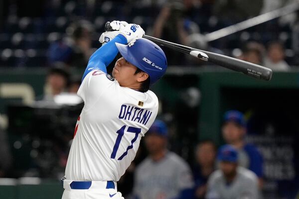 Los Angeles Dodgers' Shohei Ohtani follows through ona fly out to left in the first inning of an MLB Tokyo Series baseball game against the Chicago Cubs in Tokyo, Japan, Wednesday, March 19, 2025. (AP Photo/Eugene Hoshiko)