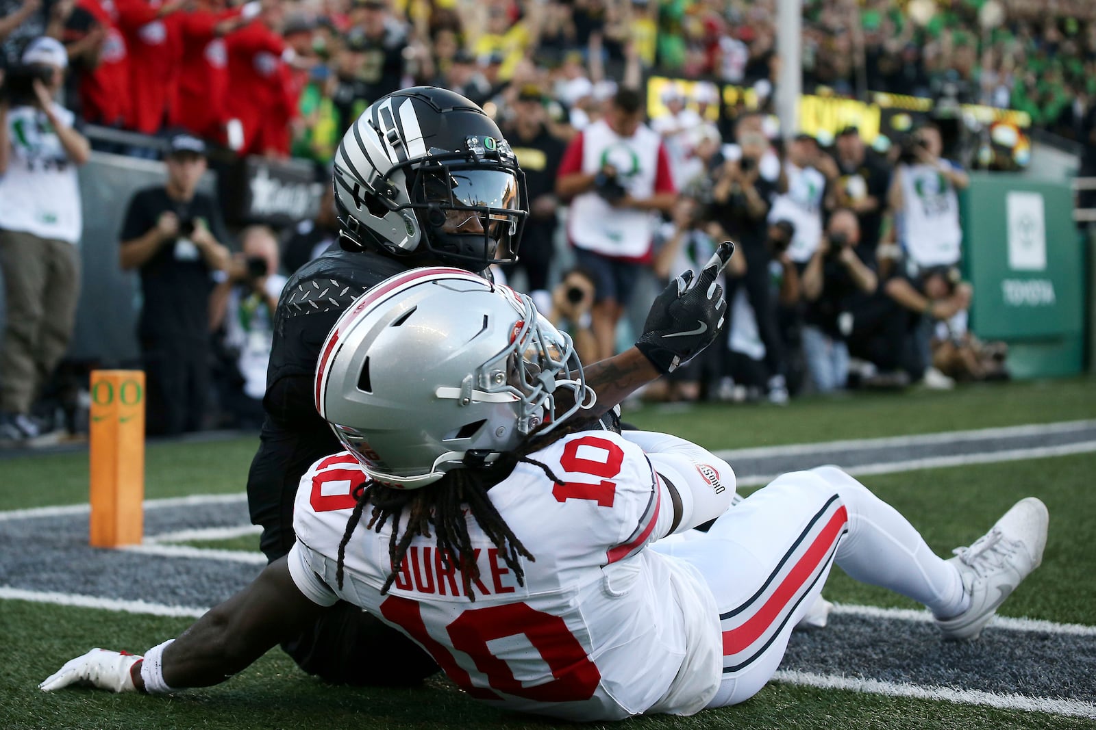 Oregon wide receiver Evan Stewart, top, celebrates after a touchdown against Ohio State cornerback Denzel Burke (10) during an NCAA college football game, Saturday, Oct. 12, 2024, in Eugene, Ore. (AP Photo/Lydia Ely)