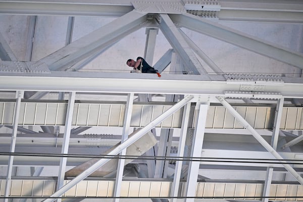 A employee labors on the catwalk of AT&T Stadium prior to an NFL football game between the Dallas Cowboys and the Houston Texans, Monday, Nov. 18, 2024, in Arlington. (AP Photo/Jerome Miron)