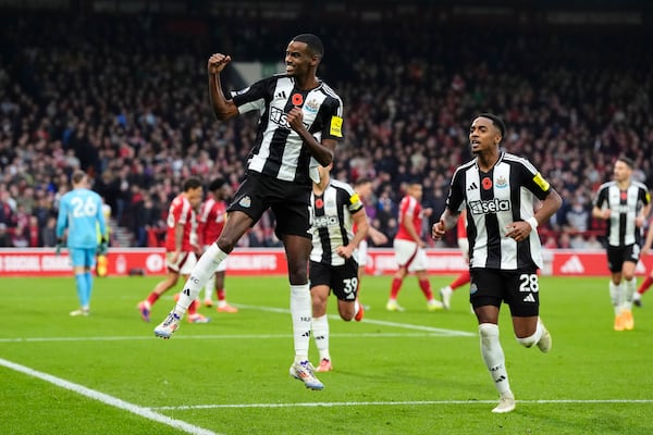 Newcastle United's Alexander Isak, left, celebrates after scoring their side's first goal of the game during the Premier League match between Nottingham Forest and Newcastle United, at the City Ground stadium, Nottingham, England, Sunday Nov. 10, 2024. (Nick Potts/PA via AP)