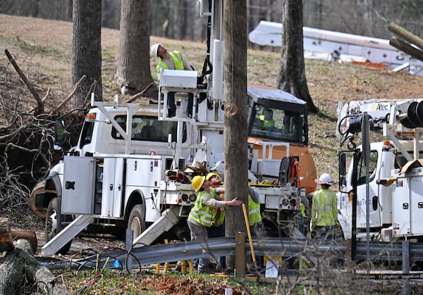 Utility workers work on power lines after a storm passed through, Sunday, March 16, 2025, in Dallas. National Weather Service teams will be conducting a damage survey in the Paulding County/Dallas area, which sustained “pretty significant” damage from the storms, NWS Senior Meteorologist Dylan Lusk told The Atlanta Journal-Constitution on Sunday morning. (Hyosub Shin / AJC)