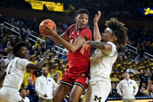 Rutgers guard Ace Bailey, middle, tries to get around Michigan guards Tre Donaldson, right, and L.J. Cason during the first half of an NCAA college basketball game, Thursday, Feb. 27, 2025, in Ann Arbor, Mich. (AP Photo/Jose Juarez)