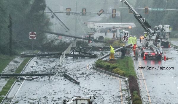 Power crews work to repair downed lines on Old Alabama Road in Johns Creek. JOHN SPINK / JSPINK@AJC.COM