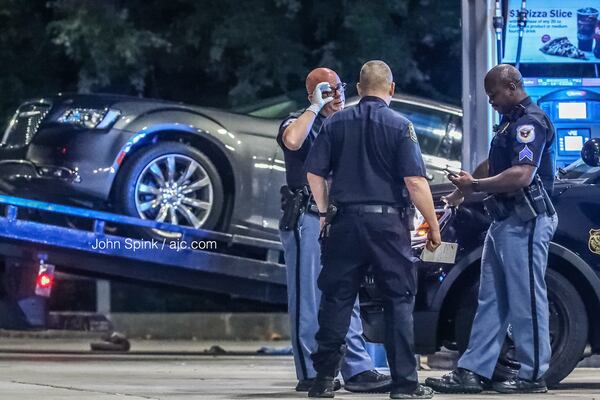 A car is towed from a RaceTrac gas station on South Cobb Drive after two people showed up shot Tuesday morning. Investigators are looking into the possibility they were among those shot at a Waffle House on Fulton Industrial Bouelvard about 4 a.m.