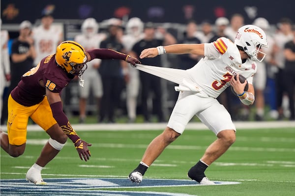 Iowa State quarterback Rocco Becht (3) attempts to escape the grasp of Arizona State linebacker Martell Hughes (18) in the second half of the Big 12 Conference championship NCAA college football game, in Arlington, Texas, Saturday Dec. 7, 2024. (AP Photo/LM Otero)