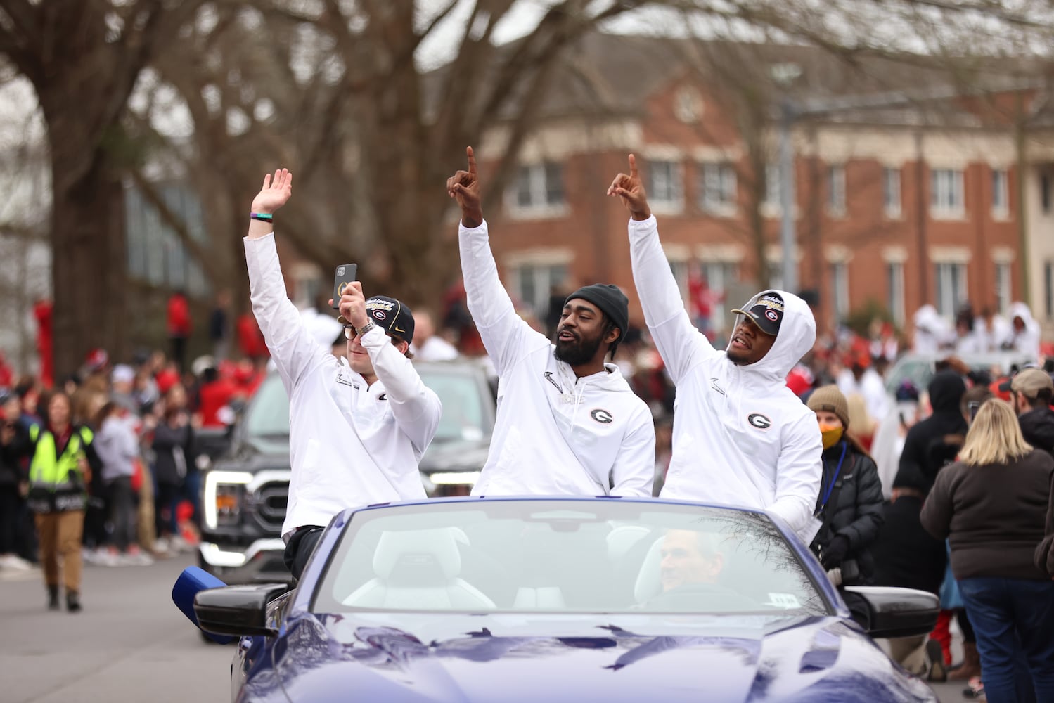 Georgia Bulldog players cheer with the crowds as the parade passes through S Lumpkin Street at the UGA campus. Saturday, January 15, 2022 Miguel Martinez for The Atlanta Journal-Constitution