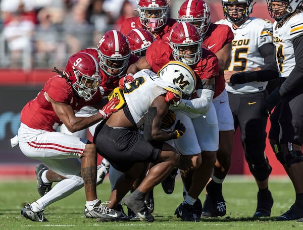 Alabama defensive back Jaylen Mbakwe, left, linebacker Que Robinson (34) and linebacker Jihaad Campbell (11) stop a run by Missouri running back Marcus Carroll, center front, during the first half of an NCAA college football game, Saturday, Oct. 26, 2024, in Tuscaloosa, Ala. (AP Photo/Vasha Hunt)