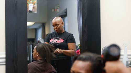 Felicia Flores, founder of Baldie Con dries her client Erica Bledsoe’s hair at her salon in Buckhead on Wednesday, Sept. 25, 2024. Flores launched Baldie Con a few years ago for women, children and men with hair loss issues. (Natrice Miller/ AJC)