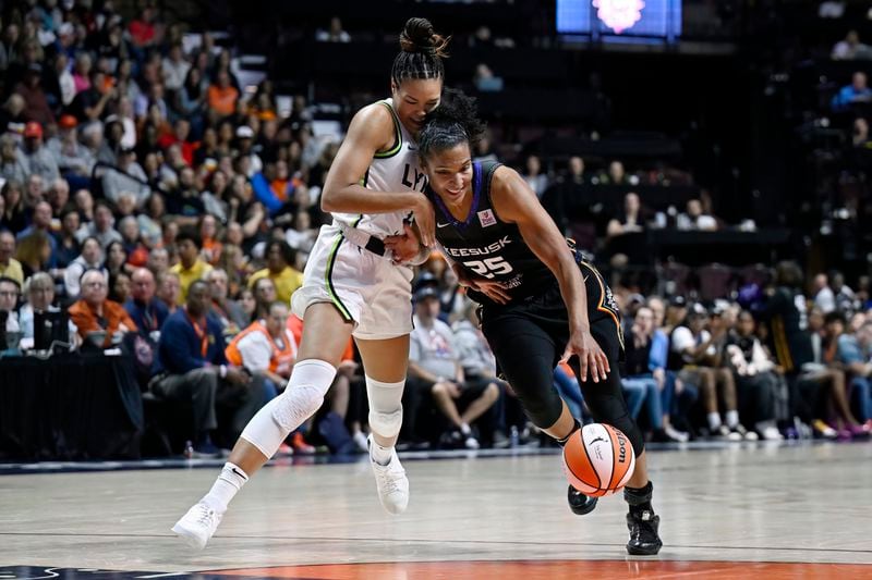 Minnesota Lynx forward Napheesa Collier, left, guards Connecticut Sun forward Alyssa Thomas during the second half of Game 4 in the WNBA basketball semifinals, Sunday, Oct. 6, 2024, in Uncasville, Conn. (AP Photo/Jessica Hill)