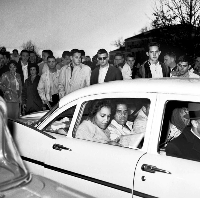 University of Georgia students shout and jeer at Charlayne Hunter (left), 18, and Hamilton Holmes, 19, as they leave the administration building after completing registration in January 1961. Admitted under federal court order, they were the first Black students to attend the university in its history. (1961 AP photo)