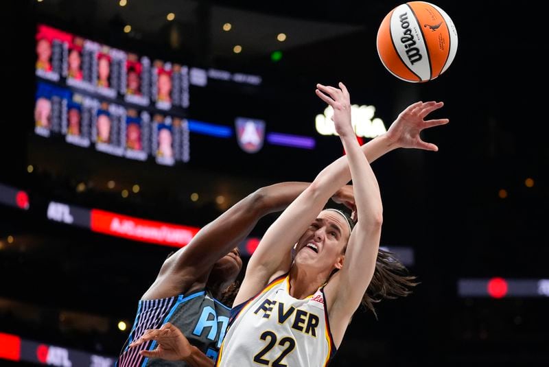 Indiana Fever guard Caitlin Clark (22) battles Atlanta Dream center Tina Charles (31) for a rebound in the first half of a WNBA basketball game Friday, June 21, 2024, in Atlanta. (AP Photo/John Bazemore)