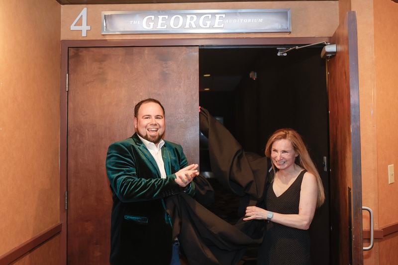 (Left to right) Tara Theatre owner Christopher Escobar and Stacey Lefont, the daughter of George Lefont unveil The George Auditorium on Thursday, May 25, 2023. George Lefont purchased the Tara in the 1980s and begin screening indie films at the theatre. (Natrice Miller/natrice.miller@ajc.com)