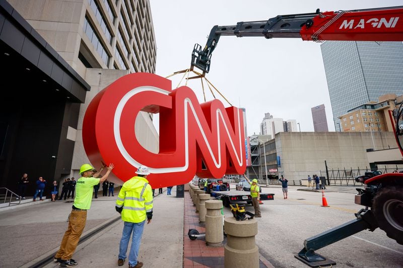 After hours of work, a crane lifts the iconic CNN sign onto a flatbed truck Monday. The famous symbol will be renovated and relocated to the cable network's new home in Midtown.