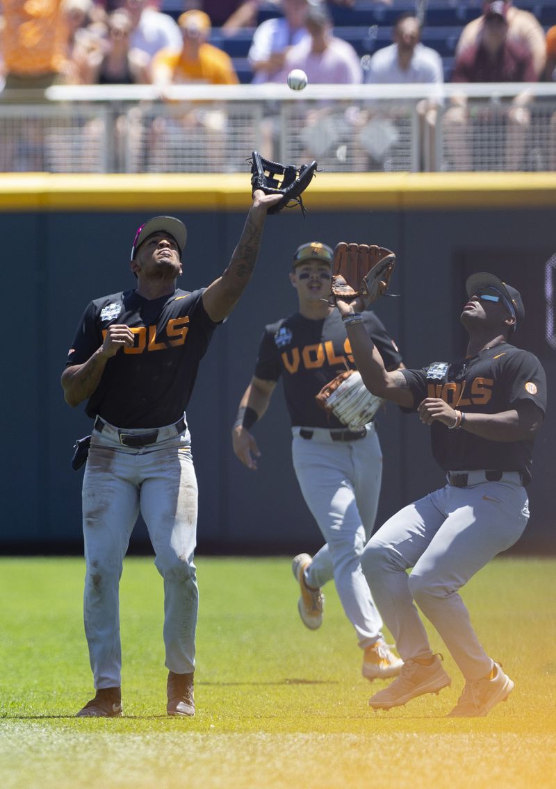 Tennessee's Christian Moore, left, catches a fly ball hit by Texas A&M's Gavin Grahovac alongside Kavares Tears, right, in the first inning of Game 2 of the NCAA College World Series baseball finals in Omaha, Neb., Sunday, June 23, 2024. (AP Photo/Rebecca S. Gratz)
