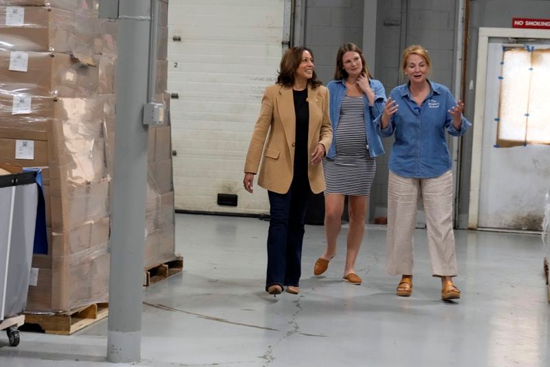 Democratic presidential nominee Vice President Kamala Harris walks with co-owners of Port City Pretzels, Eileen Marousek, center, and her mother, Suzanne Foley, as she campaigns in Portsmouth, N.H., Wednesday, Sept. 4, 2024. (AP Photo/Jacquelyn Martin)