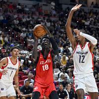 Atlanta Hawks forward Mouhamed Gueye (18) shoots between Washington Wizards guard Johnny Davis (1) and center Alex Sarr (12) during the first half of an NBA summer league basketball game Friday, July 12, 2024, in Las Vegas. (AP Photo/David Becker)