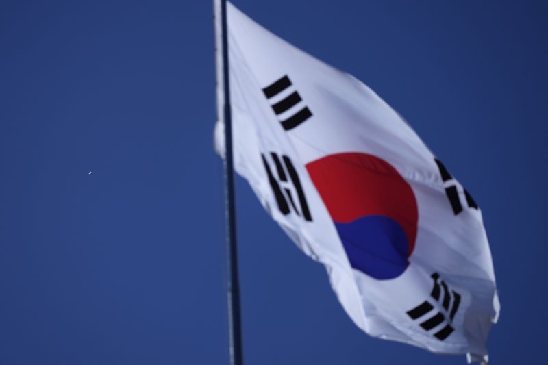 A South Korean national flag flutters in the wind at the Unification Observation Post as North Korean balloons, left, fly in Paju, South Korea, near the border with North Korea, Friday, Oct. 4, 2024. (AP Photo/Lee Jin-man)