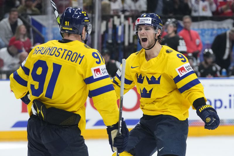 Sweden's Carl Grundstrom, left, celebrates with Sweden's Adrian Kempe after scoring his sides third goal during the bronze medal match between Sweden and Canada at the Ice Hockey World Championships in Prague, Czech Republic, Sunday, May 26, 2024. (AP Photo/Petr David Josek)