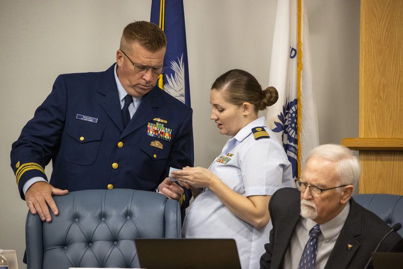 Guard investigative board member Thomas Whalen, Coast, left, and Katie Williams, of the Coast Guard, right, huddle Tuesday, Sept. 17, 2024, during a recess for the Titan marine board formal hearing, in North Charleston, S.C. (Andrew J. Whitaker/The Post And Courier via AP, Pool)