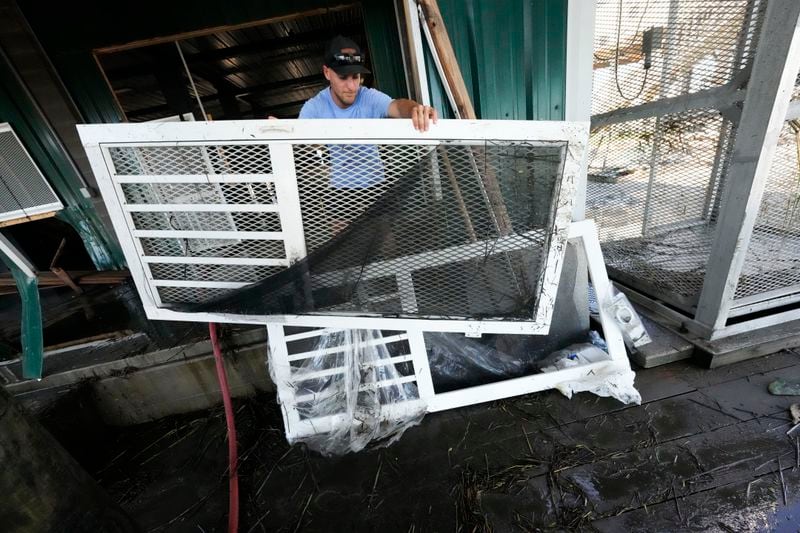 Jansen Pellegrin puts out damaged doors as he helps clean out his family's camp, that took on a storm surge, in the aftermath of Hurricane Francine, in Cocodrie, La., Thursday, Sept. 12, 2024. (AP Photo/Gerald Herbert)