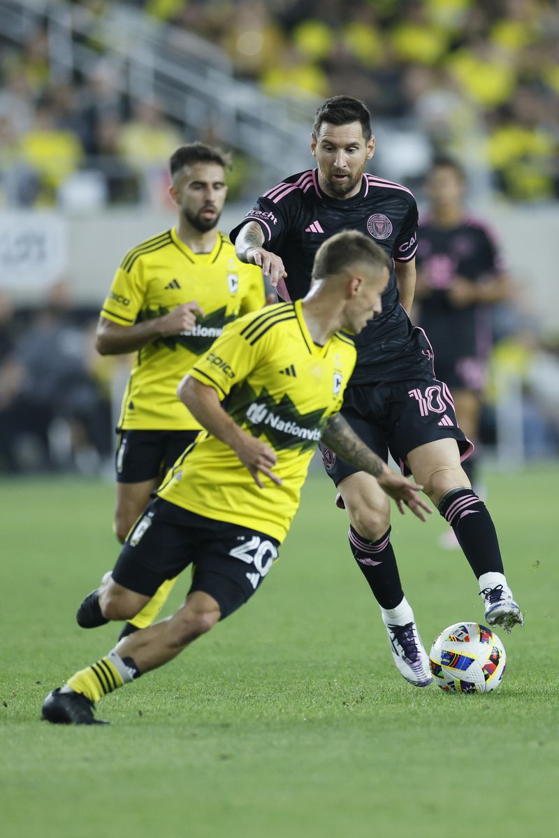 Inter Miami's Lionel Messi, right, dribbles the ball against Columbus Crew's Alexandru Matan during the first half of an MLS soccer match, Wednesday, Oct. 2, 2024, in Columbus, Ohio. (AP Photo/Jay LaPrete)