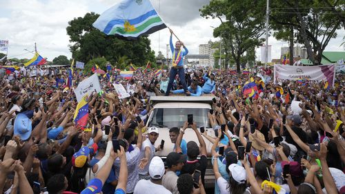 Opposition leader Maria Corina Machado waves a Monagas state flag as she greets supporters during a campaign rally for presidential candidate Edmundo Gonzalez, in Maturin, Venezuela, Saturday, July 20, 2024. The presidential election is set for July 28. (AP Photo/Matias Delacroix)