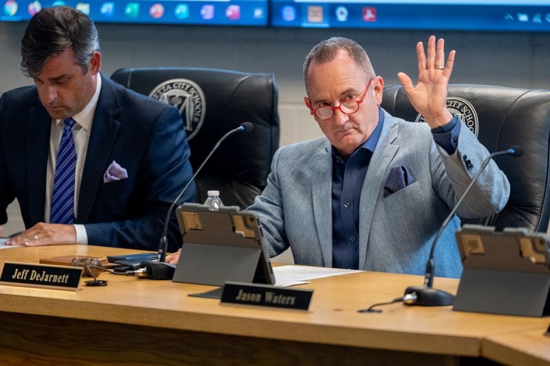 Marietta City Schools board member Jeff DeJarnett raises his hand in May in support of a measure restricting the use of cellphones in the school district's middle schools. (Ben Hendren for the Atlanta Journal-Constitution)