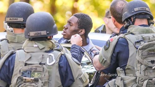 Marietta police load an attempted robbery suspect into a vehicle after he allegedly ran inside a Springhollow Lane home, causing a standoff on Wednesday, Oct. 25, 2017.