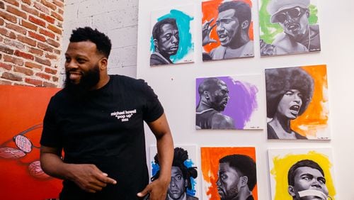Artist Michael Howell stands in front of his piece, "Black Icons," at A Marvelous Black Boy Art Show. Courtesy of Black Boy Art