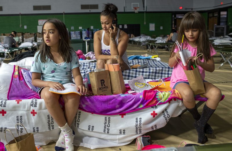 Ardis Holder, center, and her daughters Adalene, left, and Analece spend the night at a shelter in Roswell, N.M., after evacuating from Ruidoso, Tuesday, June 18, 2024. Thousands of southern New Mexico residents fled the mountainous village as a wind-whipped wildfire tore through homes and other buildings. (AP Photo/Andres Leighton)