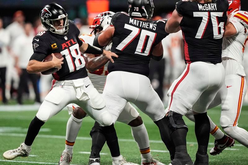 Atlanta Falcons quarterback Kirk Cousins (18) is hit by Atlanta Falcons offensive tackle Jake Matthews (70) against the Kansas City Chiefs during the first half of an NFL football game, Sunday, Sept. 22, 2024, in Atlanta. (AP Photo/Brynn Anderson)