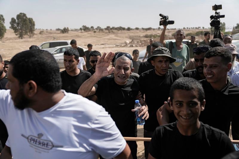 Qaid Farhan Alkadi, 52, center, who was held hostage by Hamas militants in Gaza Strip, meets his relatives and friends after arriving in the Khirbet Karkur village, near Rahat, southern Israel, Wednesday, Aug. 28, 2024. (AP Photo/Mahmoud Illean)