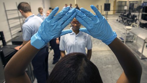 BRUNSWICK, GA - JULY 27, 2016: Transportation Security Administration Academy student Vivianette Calazan, left, of Puerto Rico trains with other student at a mock screening classroom at the new TSA Academy in Brunswick, Ga.