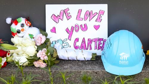 Flowers and signs are shown at the Carter Presidential Center sign in remembrance of former first lady Rosalynn Carter at the Carter Presidential Center, Tuesday, Nov. 28, 2023, in Atlanta. (Jason Getz / Jason.Getz@ajc.com)