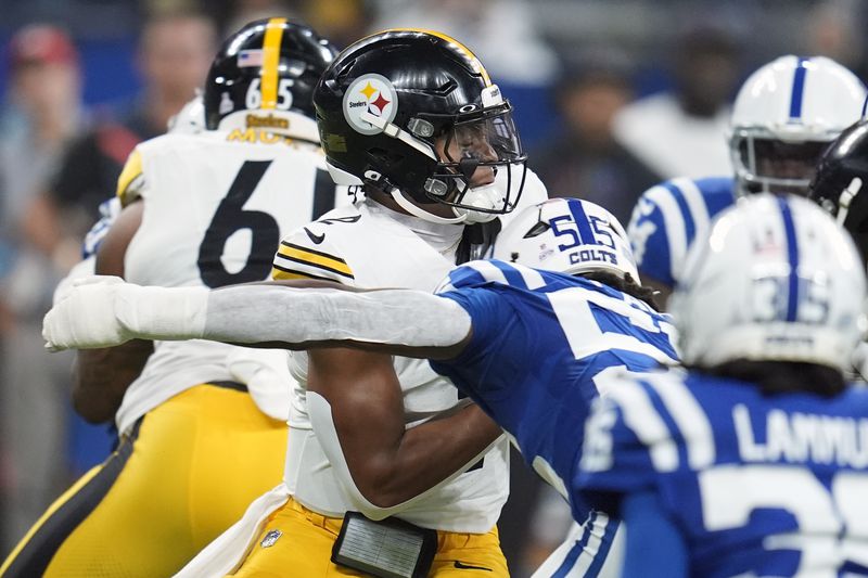 Pittsburgh Steelers quarterback Justin Fields, center, is sacked by Indianapolis Colts defensive end Isaiah Land (55) during the first half of an NFL football game Sunday, Sept. 29, 2024, in Indianapolis. (AP Photo/Michael Conroy)