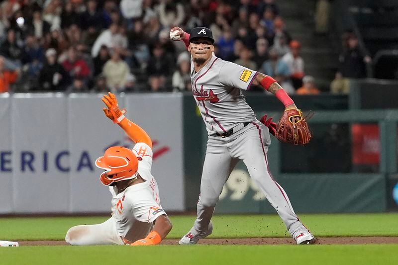 Atlanta Braves shortstop Orlando Arcia, right, throws to first base after forcing San Francisco Giants' Heliot Ramos, left, out at second base on a double play hit into by Michael Conforto during the eighth inning of a baseball game in San Francisco, Tuesday, Aug. 13, 2024. (AP Photo/Jeff Chiu)