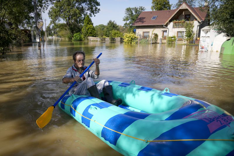 FILE - A resident paddles through a flooded street in Bohumin, Czech Republic, Sept. 17, 2024. (AP Photo/Darko Bandic, File)