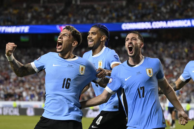 Uruguay's Mathias Olivera, left, celebrates with teammates after scoring his side's opening goal against United States during a Copa America Group C soccer match in Kansas City, Mo., Monday, July 1, 2024. (AP Photo/Reed Hoffman)
