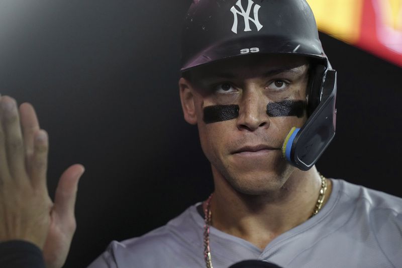 New York Yankees Aaron Judge is congratulated in the dugout after scoring against the Toronto Blue Jays during the ninth inning of a baseball game Friday, June 28, 2024, in Toronto. (Chris Young/The Canadian Press via AP)