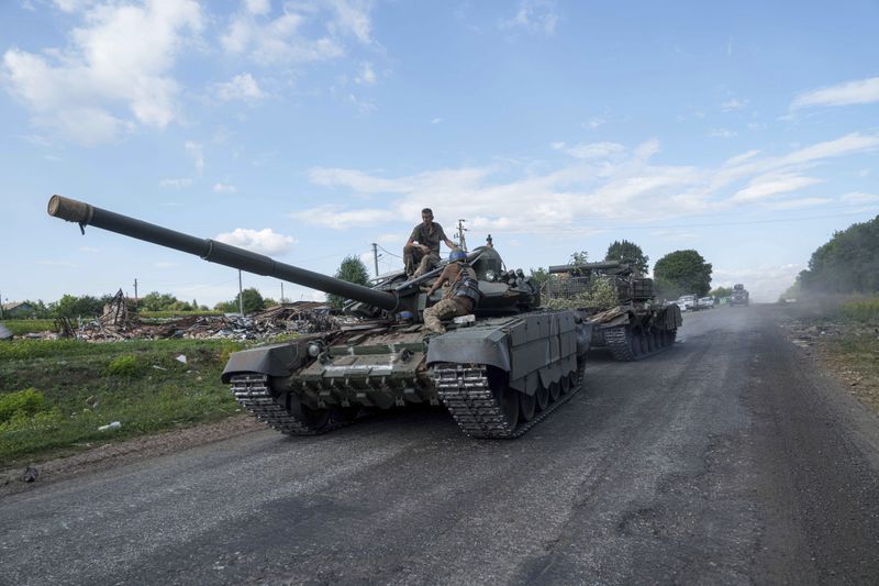 Ukrainian servicemen ride atop a tank after returning from Russia near the Russian-Ukrainian border in Sumy region, Ukraine, Thursday, Aug. 15, 2024. (AP Photo/Evgeniy Maloletka)