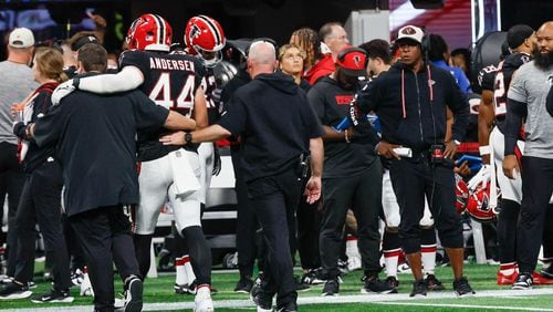 Falcons head coach Raheem Morris (right) watches linebacker Troy Andersen leave the field after an injury Sunday. (Miguel Martinez/ AJC)